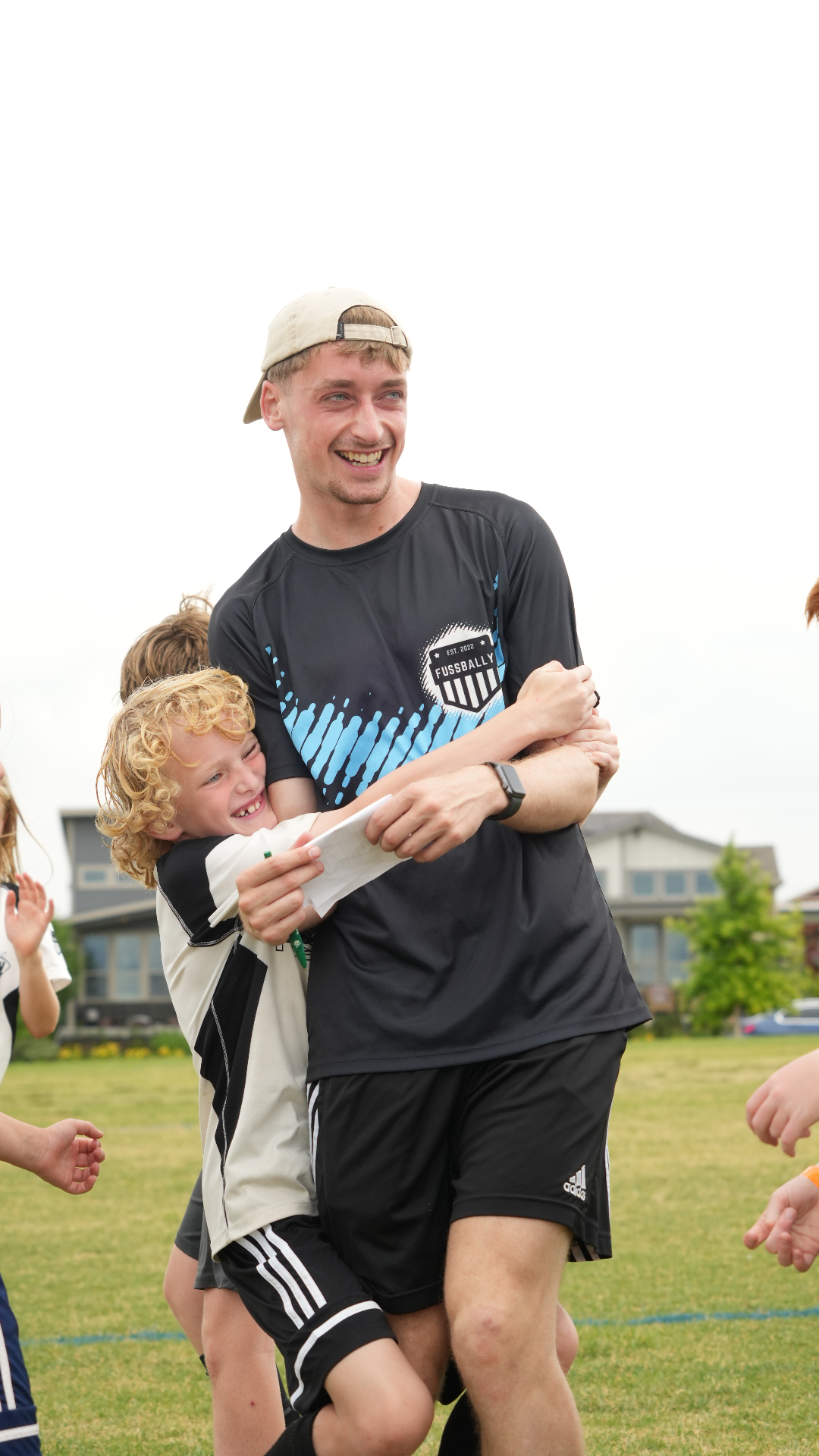 Curly-haired child hugging their Fussbally coach